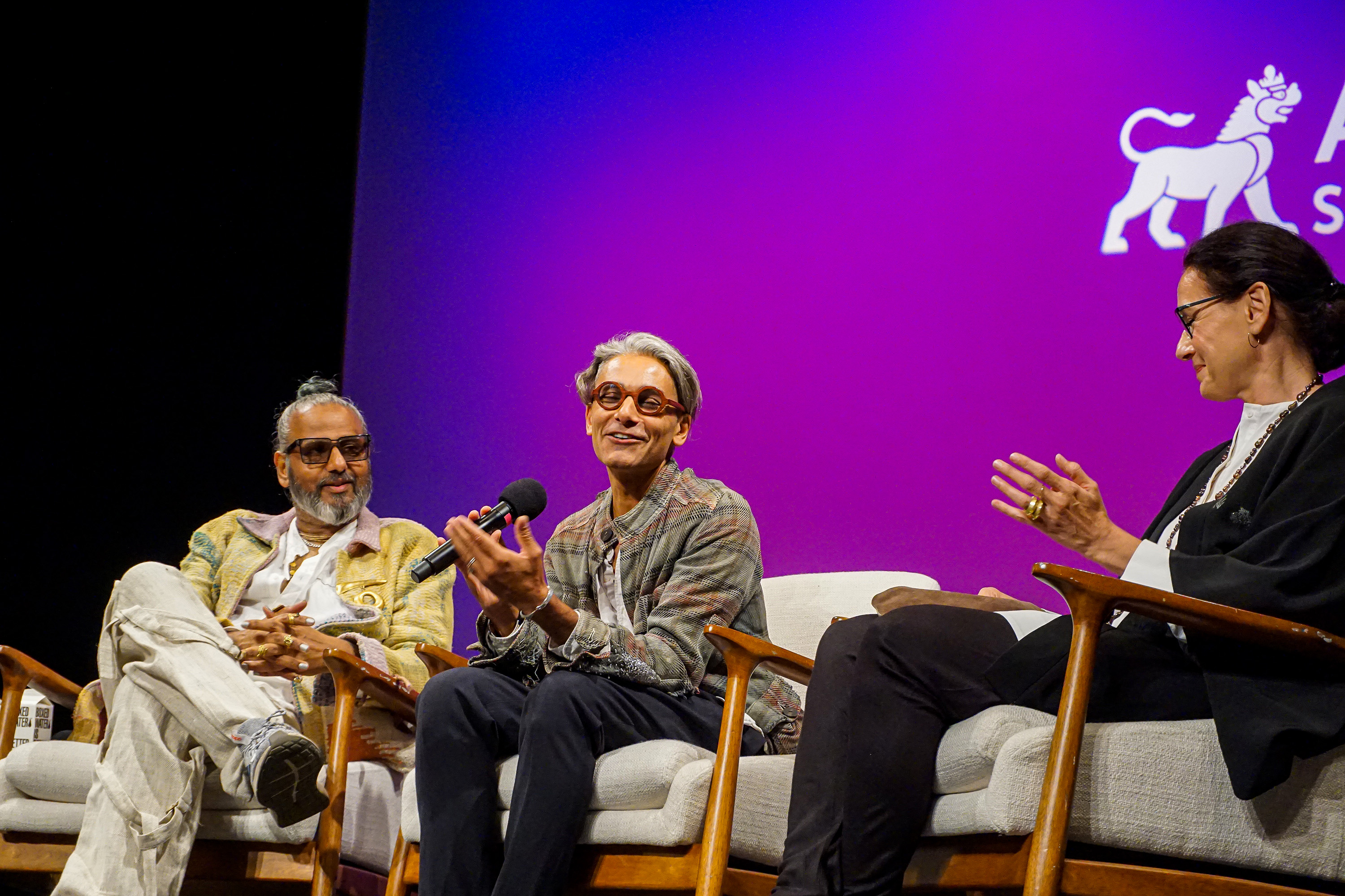 Ajay Shrivastav, Sandy Dalal and Carmen Artigas sitting in chairs on stage in a discussion panel