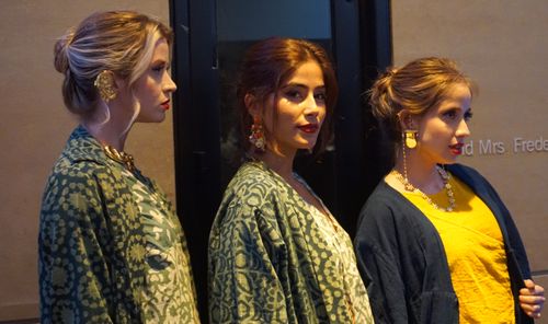 three female models lined up sideways wearing elegent Indian textiles
