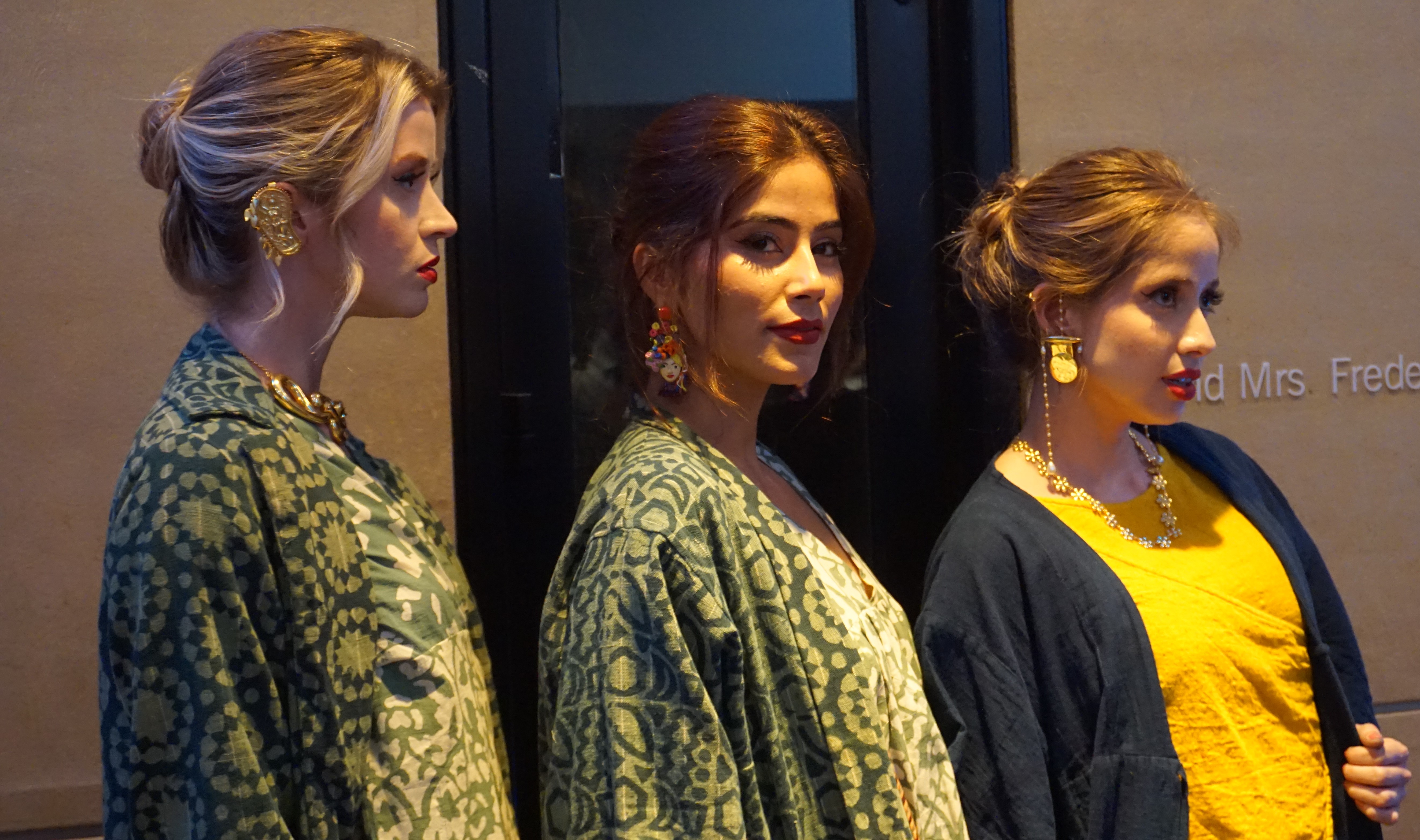 three female models lined up sideways wearing elegent Indian textiles