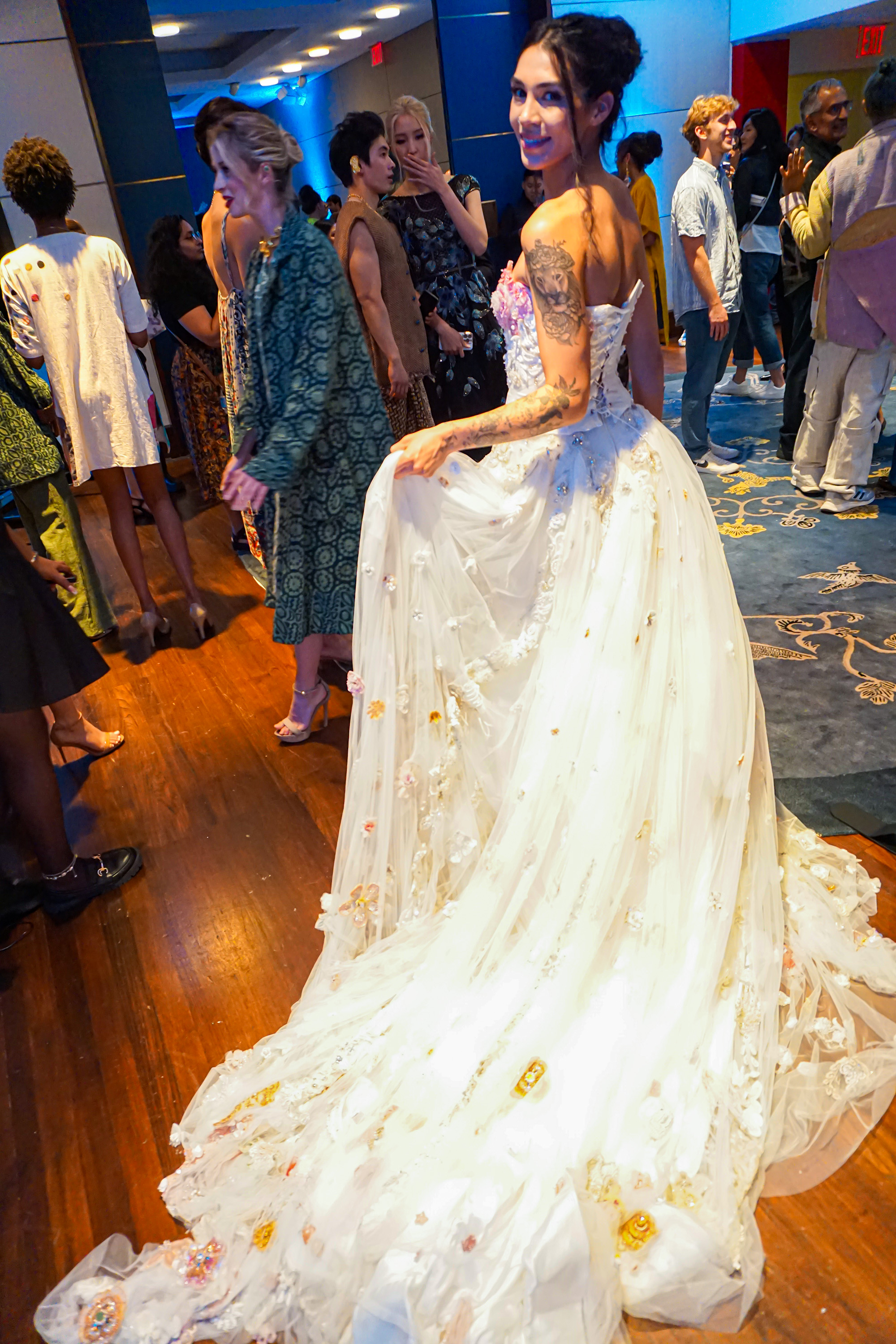 Model with very long white dress turning around facing the camera holding her dress