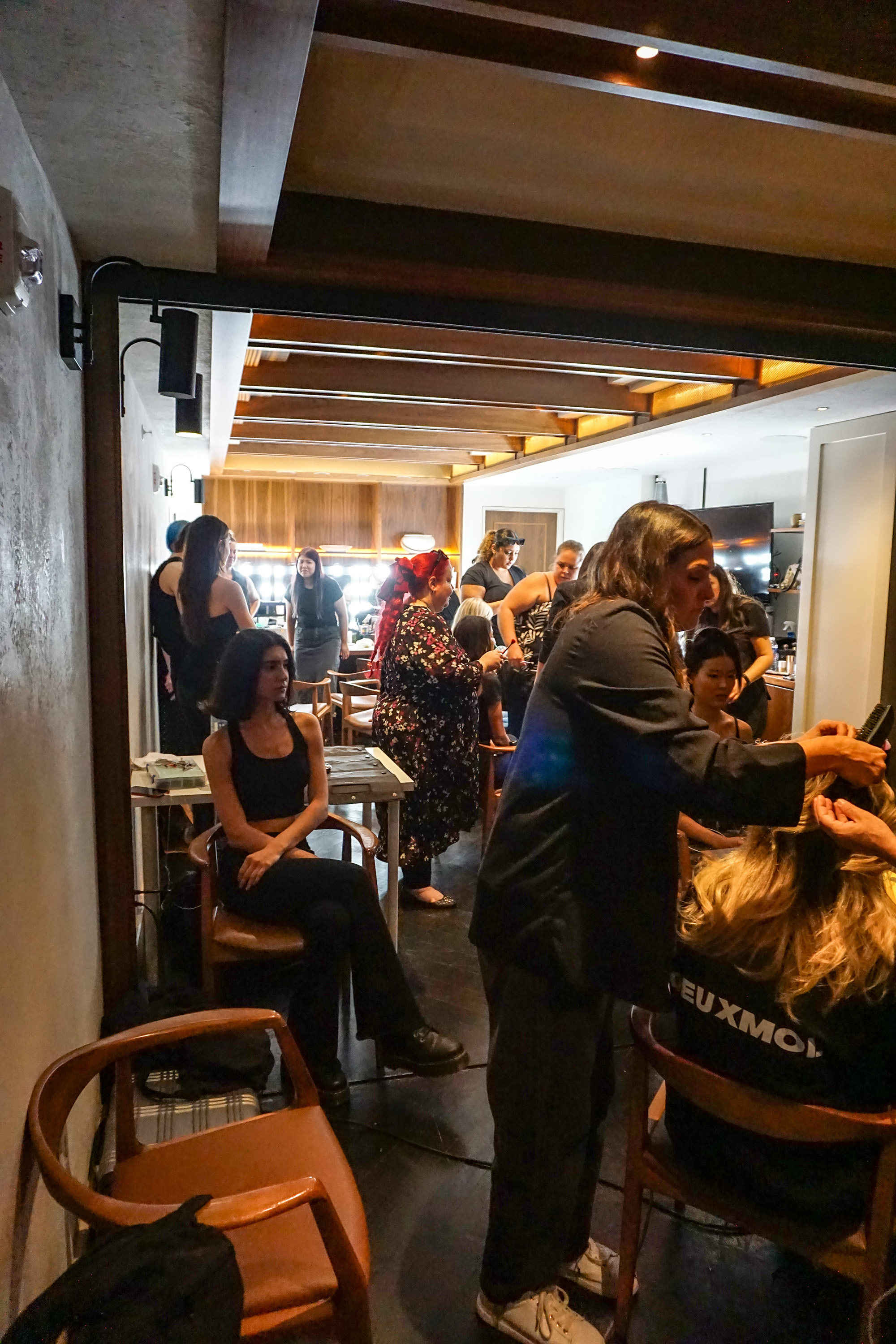 a crowded make up and hair room prepping for a fashion show