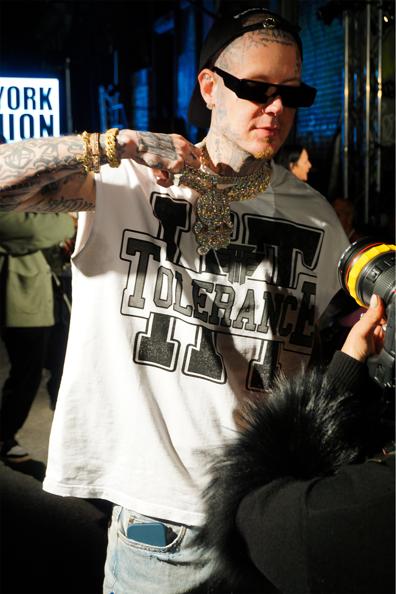 Millyz holding his chain at night time outdoors posing for a photographer