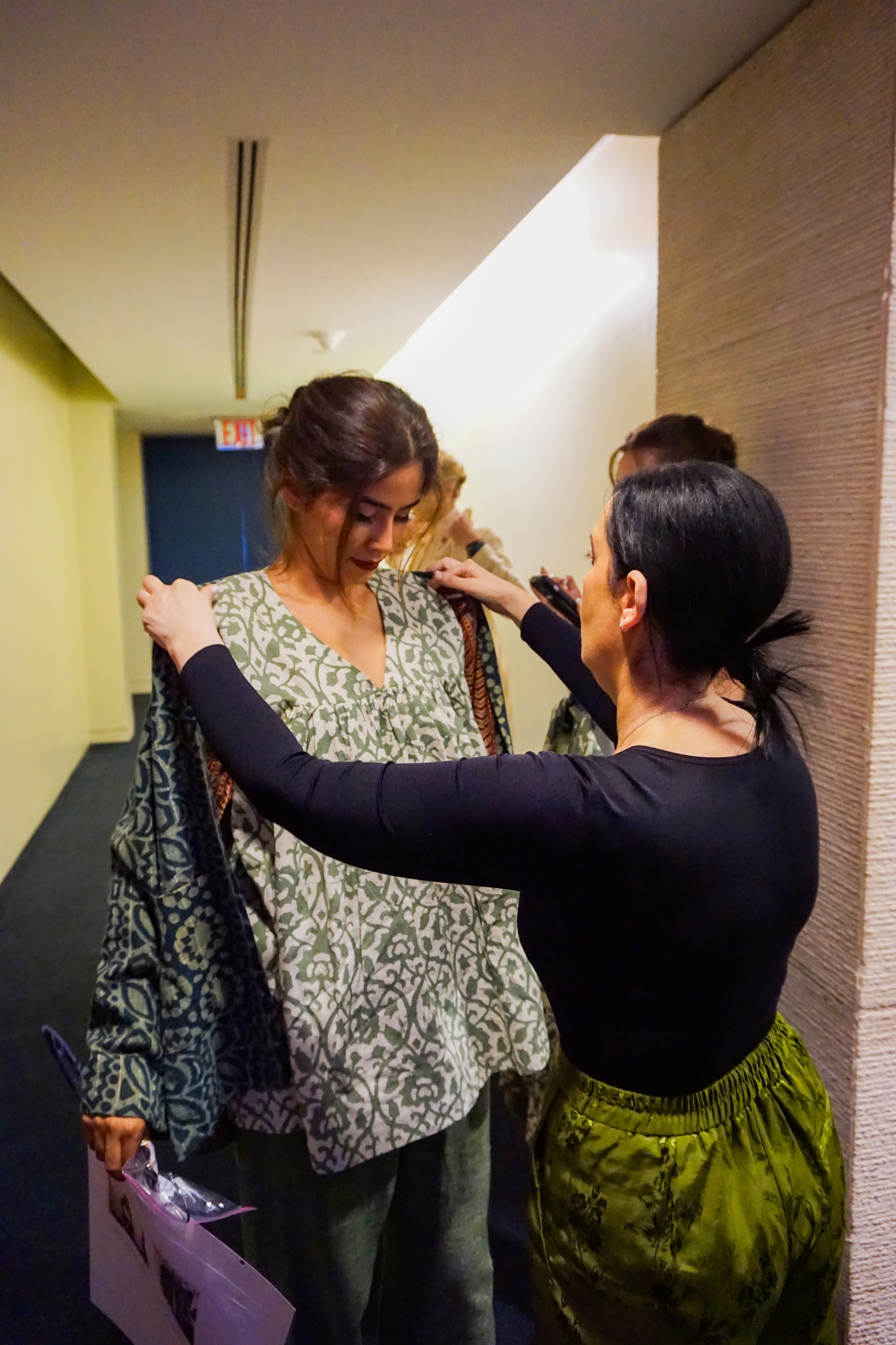 Backstage stylist dressing a model before the fashion show