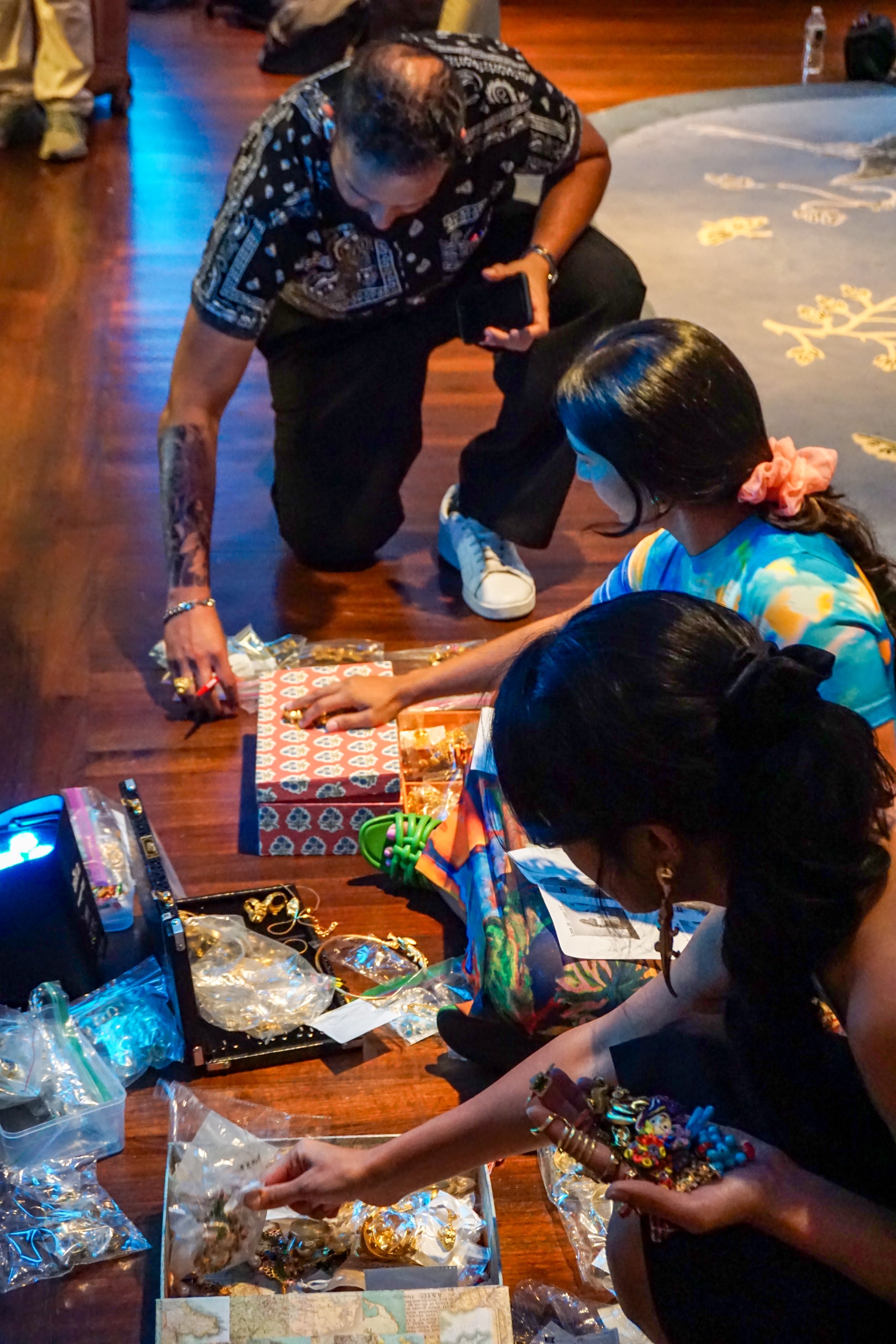 People on the floor backstage preparing jewelry for the fashion show