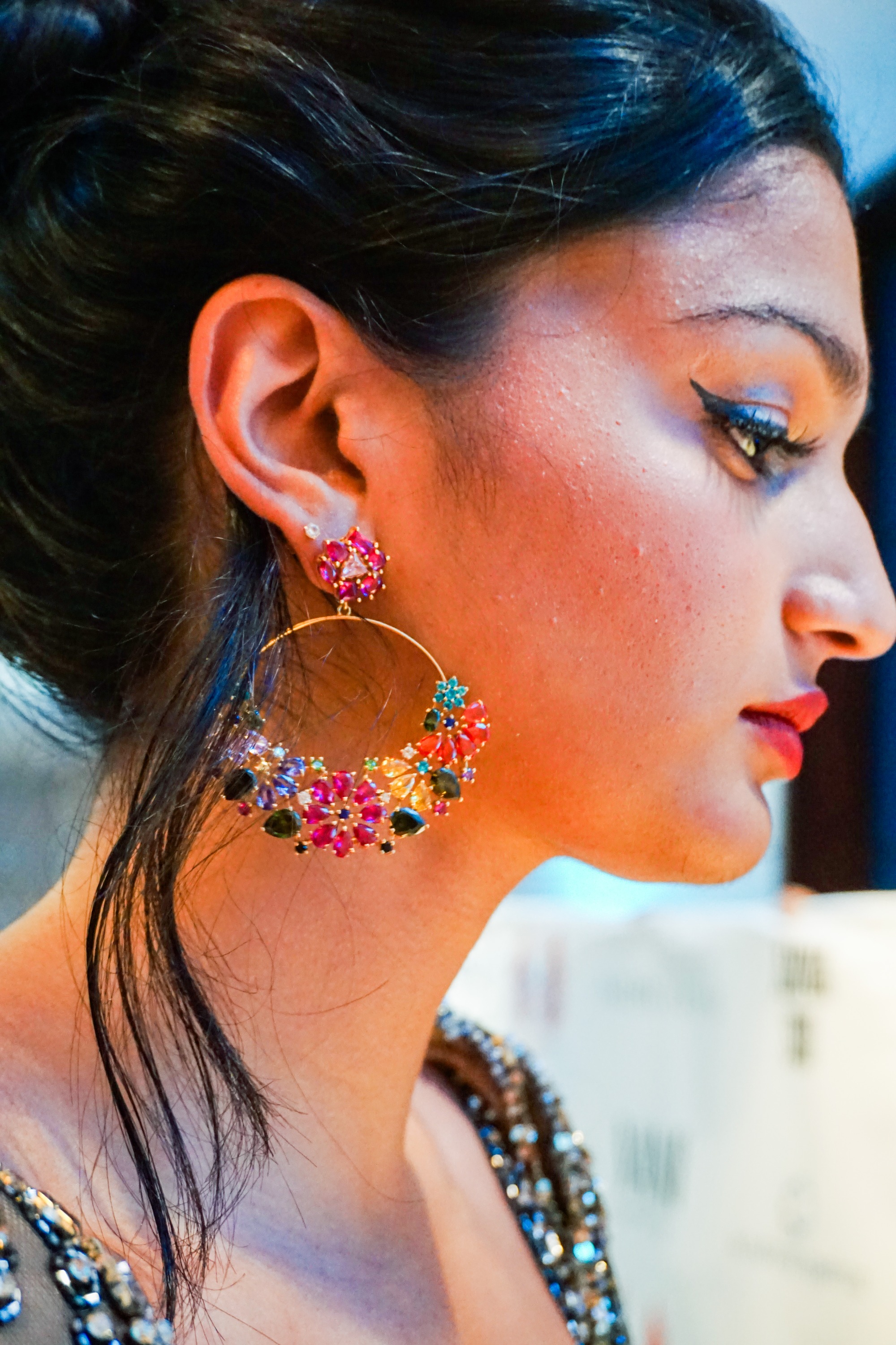 Close up side profile of a female model adorning large Indian style earrings