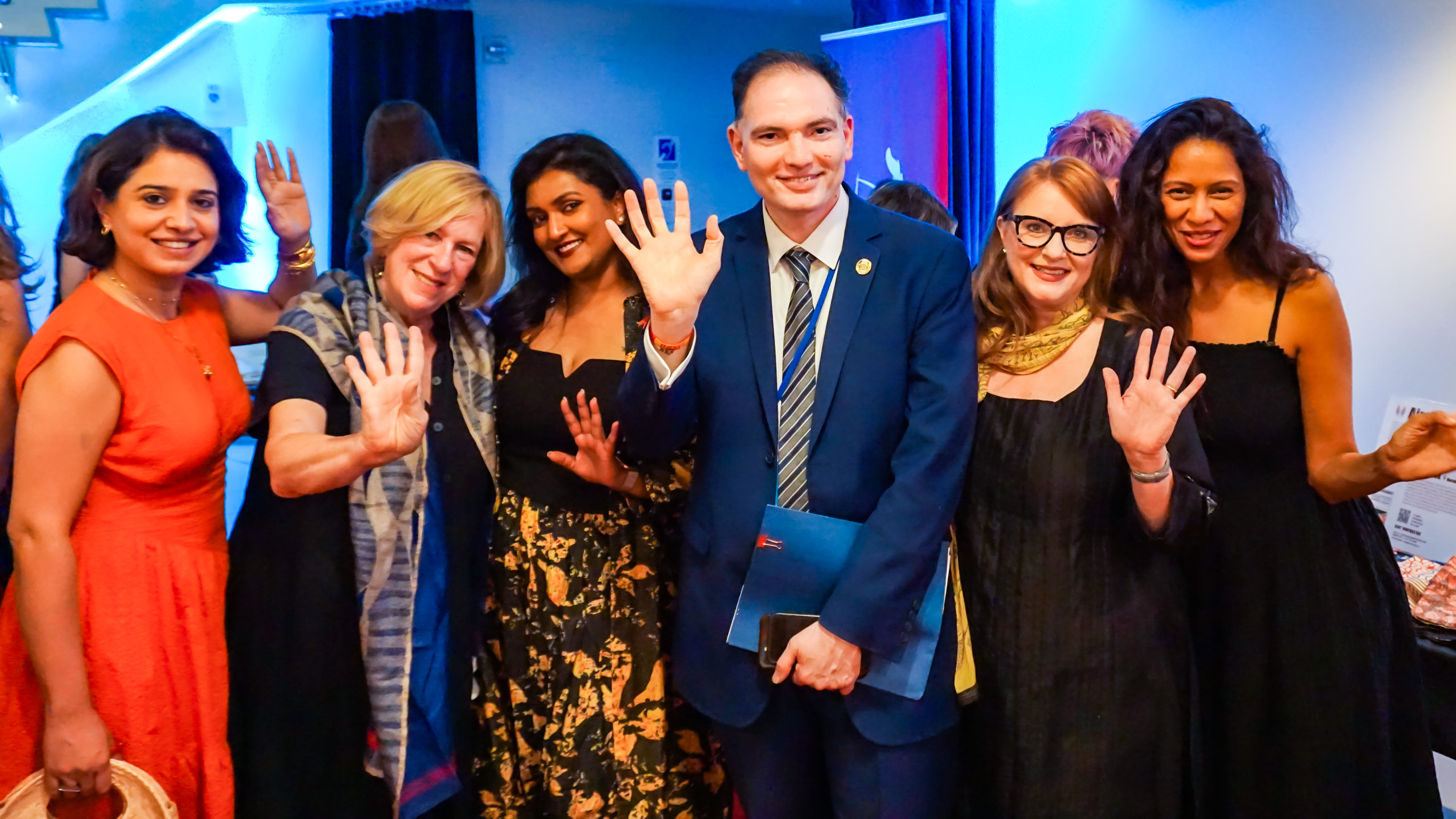 Melissa Shea, Sneha Andani, a representative from NYC government and others crowded together waving at the camera