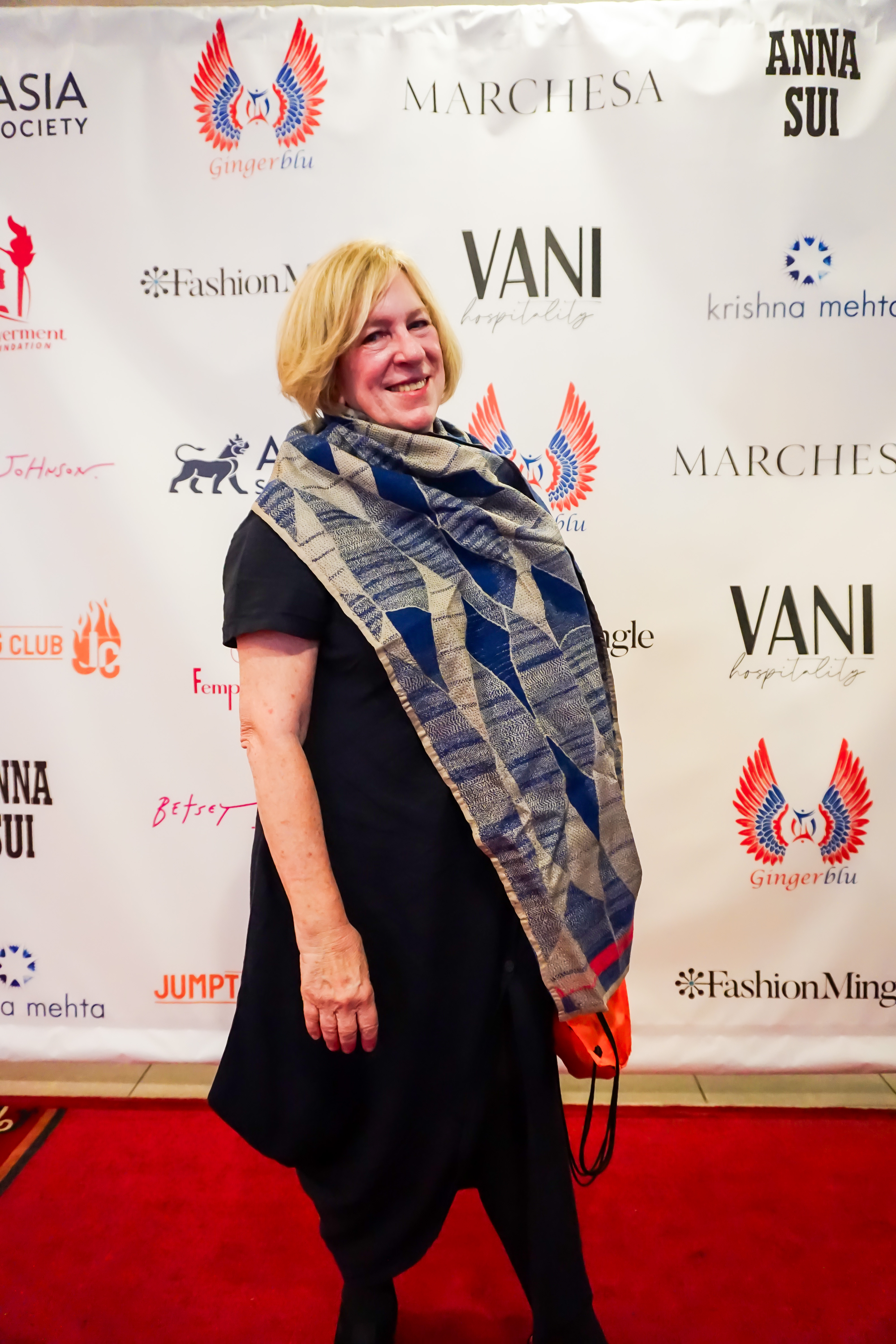 Rachel Cooper standing in front of a step and repeat banner