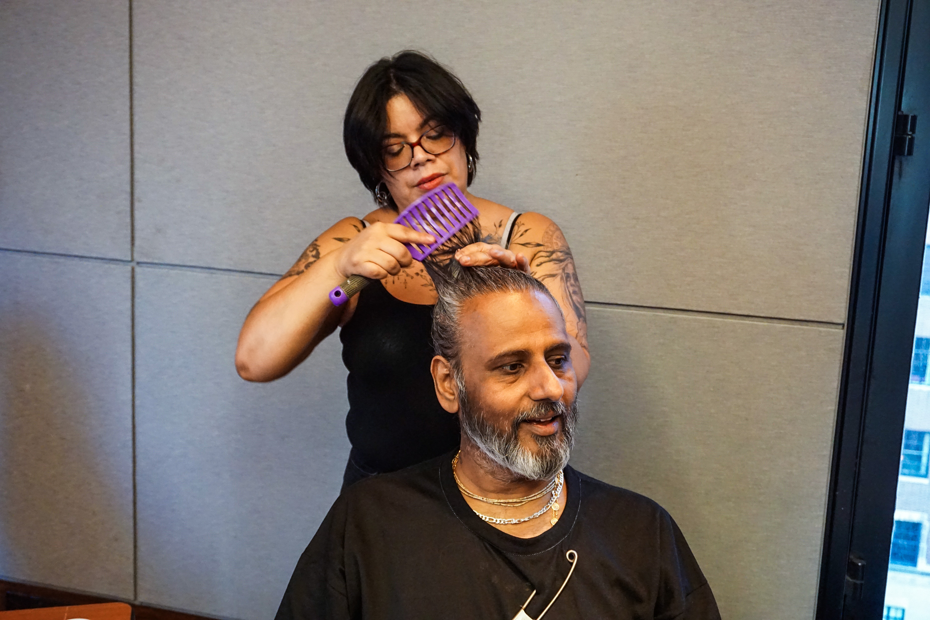 Female hair stylist doing Ajay Shrivastav's hair before the fashion show at Asia Society in New York City