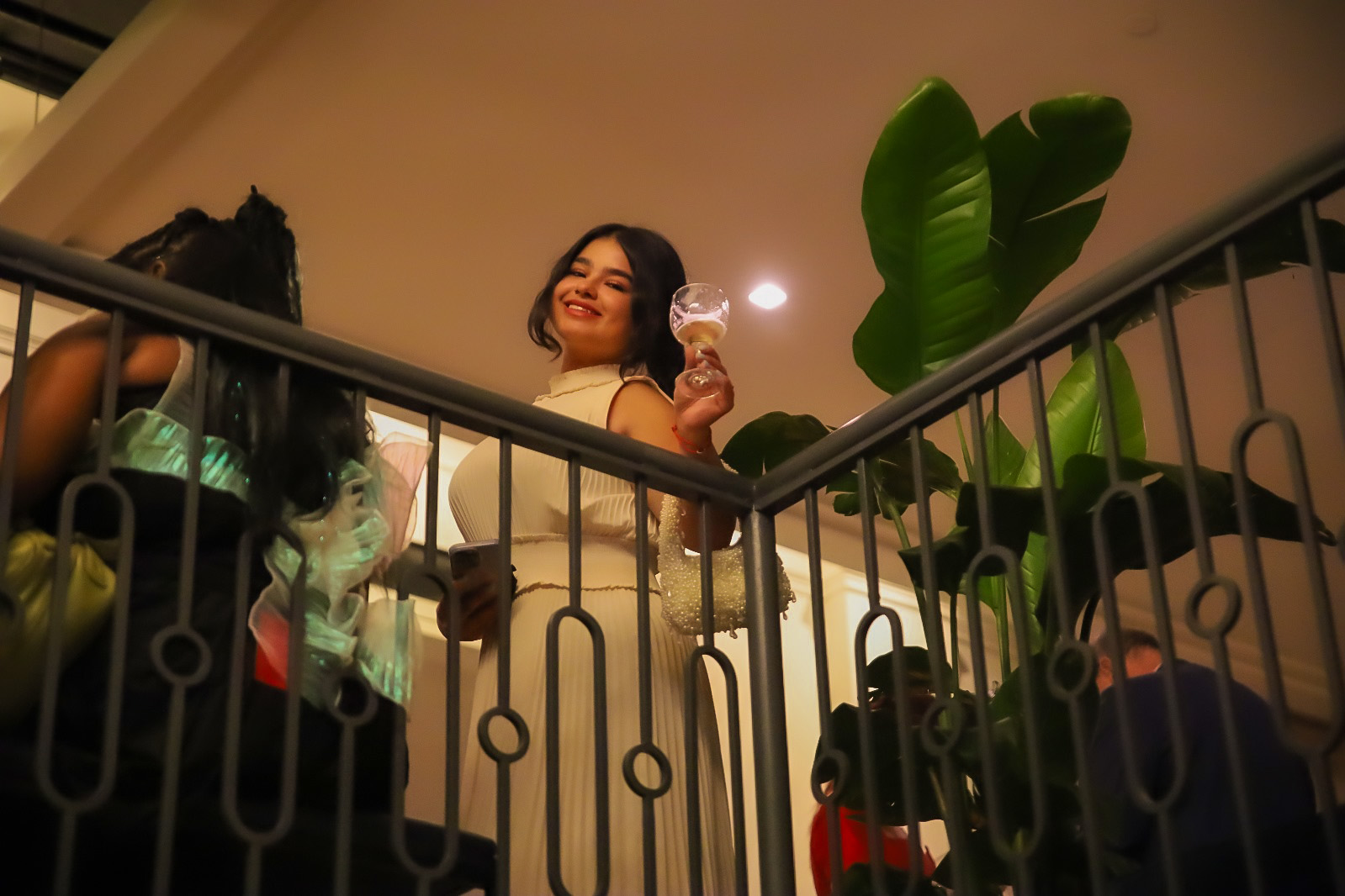 Diyora Shukhratova toasting a glass of wine on a balcony inside Walker Hotel in New York City