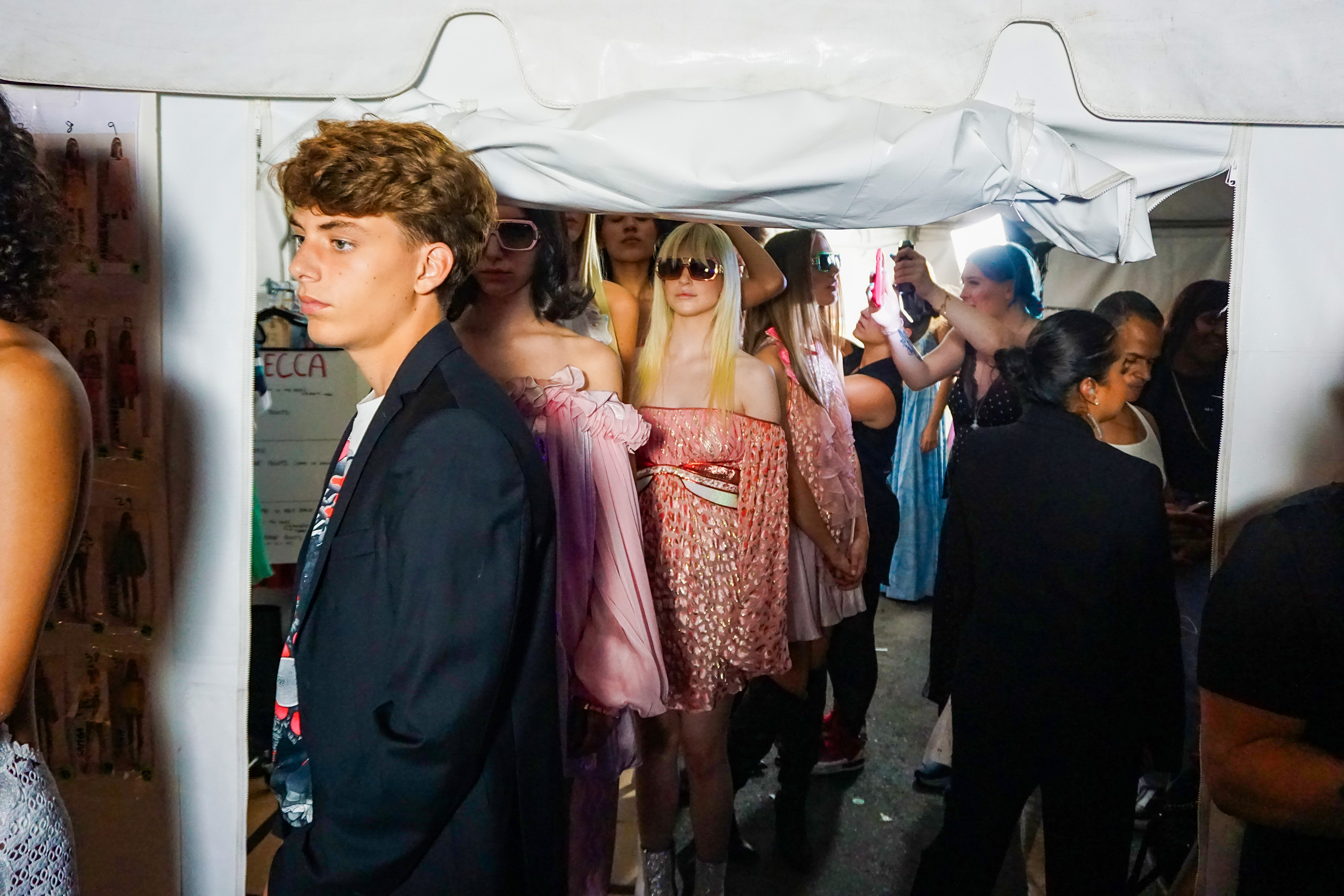 Models exiting a tent single file for entry to the runway