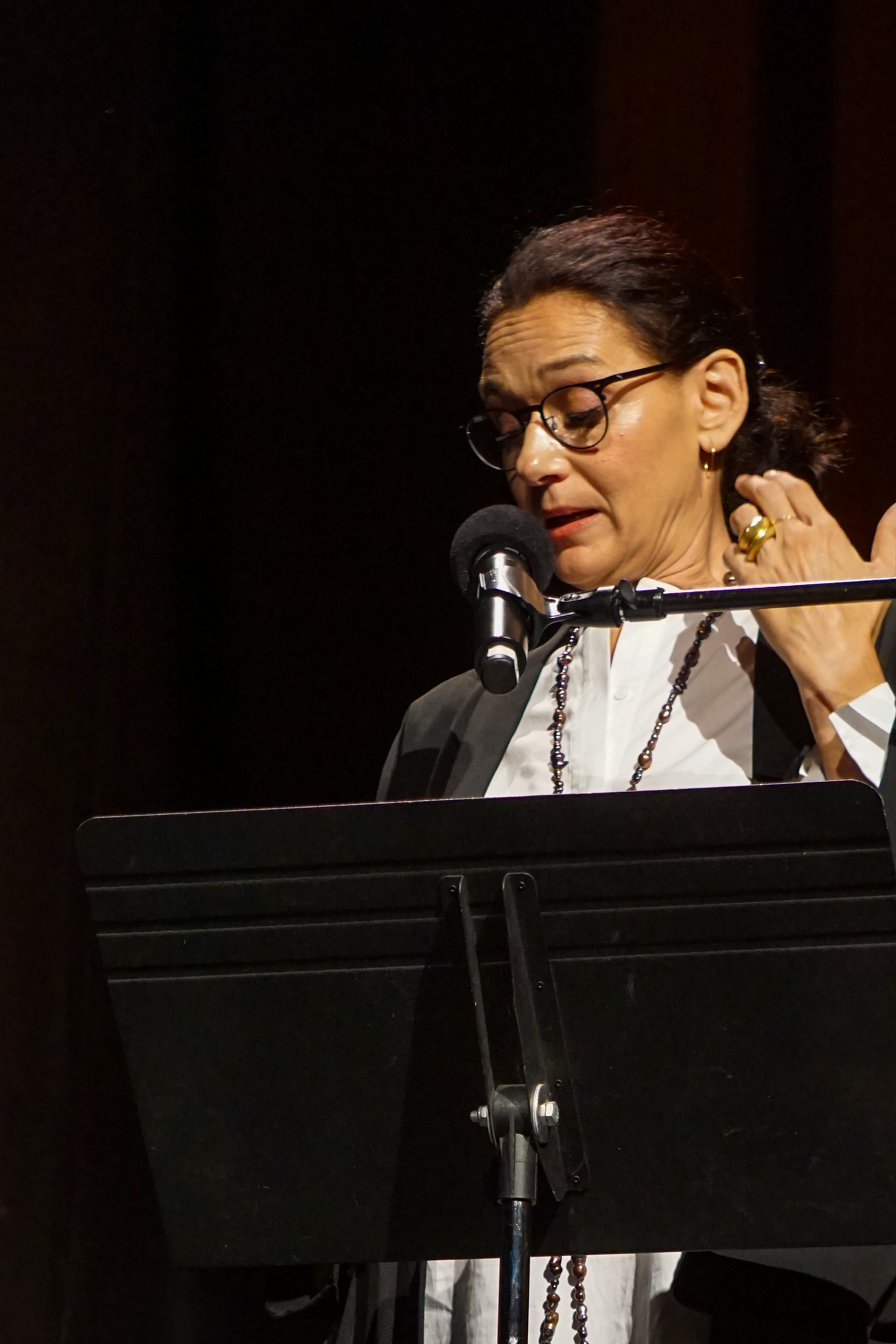 Carmen Artigas on stage making a point during her presentation with a microphone to her mouth