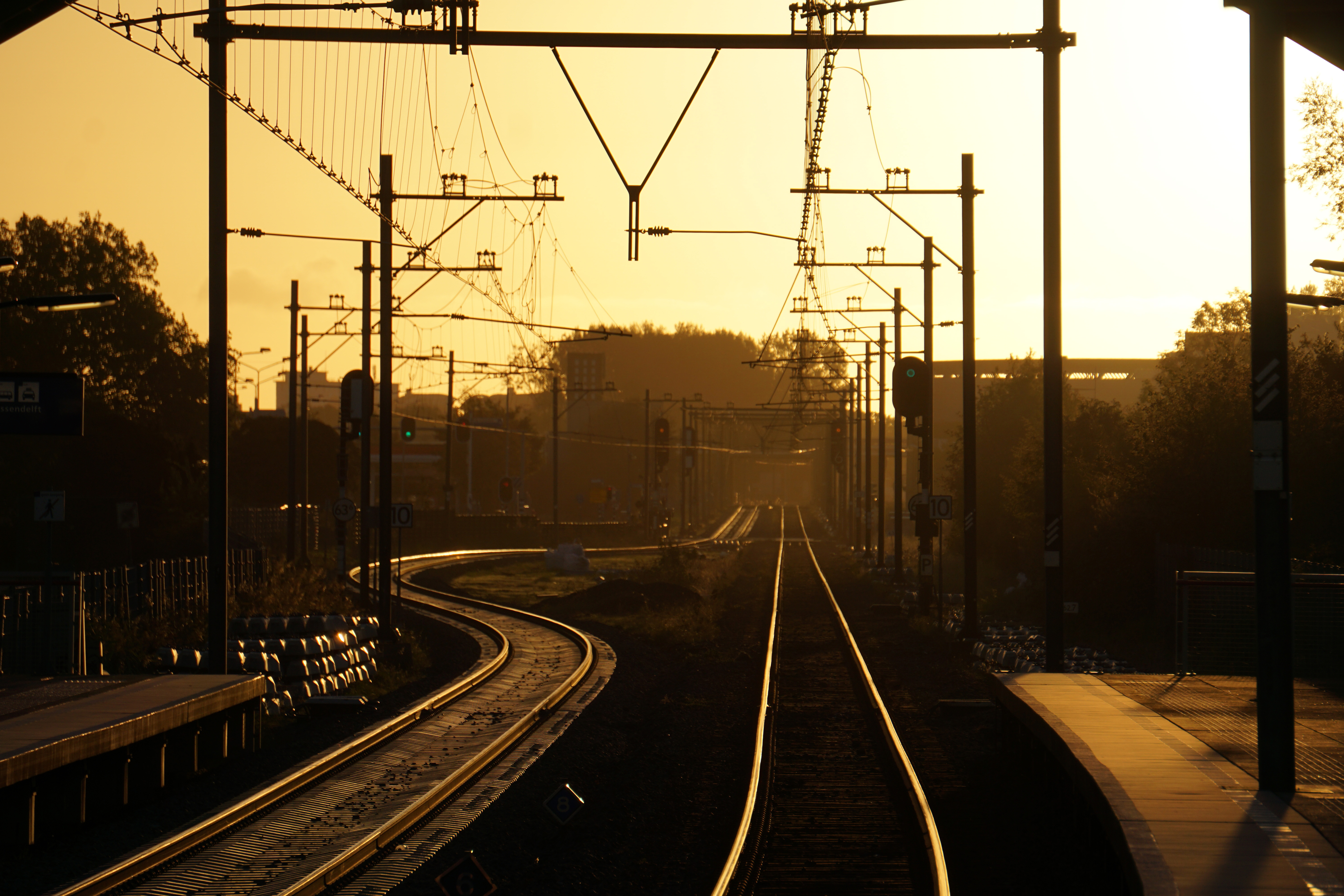 A train station in Amsterdam with an orange hazey glow at dawn